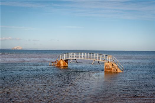 When the tide comes surging into shore, what should be an easy path to the beach becomes suddenly impassable. At high tide, the water swallows the land around the bridge, making it look as though it’s stranded in the middle of a sea.